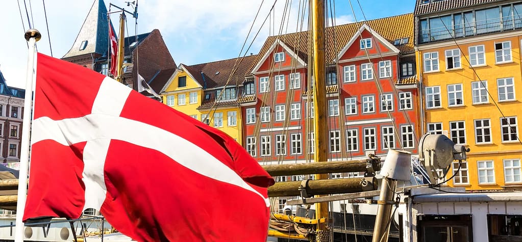 Denmark Flag and cities with colorful tall storey buildings. 